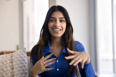 Hintli kadın kameranın önünde konuşma yapıyor, video bloğunu kanal için kaydediyor, bilgiyi veya deneyimi paylaşıyor, reklam veya tanıtım ürünü veya hizmetleri sunuyor. Etki, sosyal medya simgesi, vesikalık portre