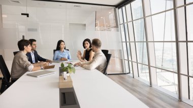 İşgücü brifingi. Çok ırklı şirket personeli modern ofis konferans odasında atölye seminerinde buluşup beyin fırtınası fikirlerini tartışarak başarı stratejisi oluşturuyorlar. Kopyalama alanı