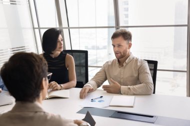 Çeşitli takım işbirliği. Milenyum girişimcisi uzman uzman, konferans odasında toplanan iş arkadaşları grubuna yaratıcı iş projesi projesi çözümü sundu