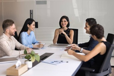 Destekleyici liderlik. Gülümseyen orta yaşlı kadın lider CEO çeşitli çok kültürlü kurumsal takımları toplantı masası brifing konferansının etrafında topladı.