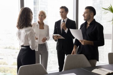Beyin fırtınası için spontane bir toplantı. Dost canlısı iş adamları grubu çeşitli takım arkadaşları ofiste dikilip gayri resmi bir konuşma yapıyorlar. Dijital kağıt dökümanlarını tartışıyorlar. Fikirlerini paylaşıyorlar.