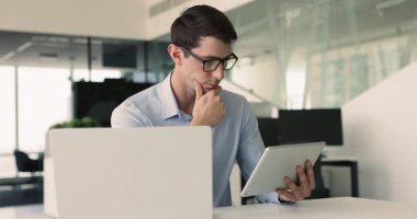 Ciddi Hispanik proje yöneticisi iş iletişimi için iş yerindeki tablet üzerinde modern teknolojiyi kullanıyor, çevrimiçi içeriği analiz ediyor, çeneye dokunuyor, İnternet pazarlama stratejisini düşünüyor