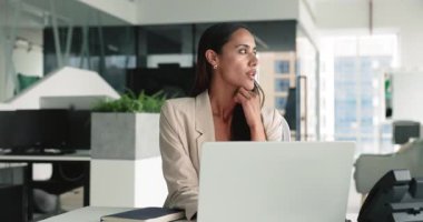 Düşünceli genç Maori iş kadını başarılı şirket ofisinde dizüstü bilgisayarla yazı yazıyor, başka yere bakıyor, online proje için yaratıcı fikirler düşünüyor, web sitesi tasarımı, çeneye dokunuyor.