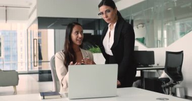 Olumlu genç profesyonellerin iyi iş çıkarması mutlu olgun bayan patrona, dizüstü bilgisayara işaret etmesi, çevrimiçi proje sunumu göstermesi, finansal satış raporu