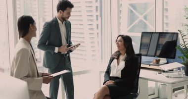 Pozitif çoklu etnik odaklanma grubu ofis çalışma alanında daireler çiziyor, konuşuyor ve gülüyor, olgun kadın lider, patron, iş uzmanı, proje yöneticisi çeşitli genç çalışanlarla konuşuyor