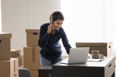 Depo görevlisi iş günü. Meşgul genç bayan posta siparişi dükkanı sahibi internet market müdürü iş yerinde telefonda karton kutuların arasında not defterindeki sipariş bilgilerini kontrol ediyor. Boşluğu kopyala