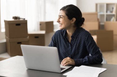 Başarılı küçük işletmeler. Mutlu gülümseyen genç bayan KME perakende veya teslimat şirketi sahibi çalışma masasında defter başında oturuyor. İnternetten siparişler alıyor, muhasebe işlerini nakliye masraflarını hazırlıyor. Boşluğu kopyala