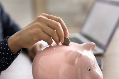 Tasarruf ve ekonomi. Yakın mesafeden kesilen genç bir kadın kumbaraya bozuk para bırakıyor. Çevrimiçi finans yatırımı güvenli e-banka mevduatının defter kavramını kullanarak yönetimini kolaylaştırır