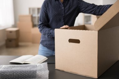 Müşteri siparişi paketliyorum. Kırpılmış vurulan kadın depo çalışanı ecommerce mağaza yöneticisi ürünü karton kutuya koymadan önce müşteri kontrol listesindeki tüm paket paketini hazırla