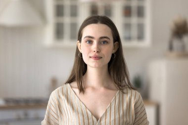 Bağımsız ve kendinden emin bir milenyum. Sosyal medyada genç ve güzel bir kadın öğrencinin evde poz verip kameraya bakıp video konuşmasının portre fotoğrafını çektim.