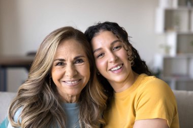 Güzel Latin kadının portresini yakın plan çek. Yetişkin kızı kameraya poz veriyor. Sevgi, bağ ve aile bağları yayıyor. Anne ve kız arasındaki güçlü ilişki ve anlayış