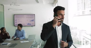 Zarif takım elbiseli yakışıklı ortadoğulu iş adamı modern konferans odasında telefonla konuşuyordu. Önemli konu tartışması, uzaktan pazarlık, iş iletişimi.