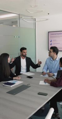 Genç 35 'lik orta doğulu işadamı, proje lideri çeşitli takım arkadaşlarıyla çağdaş konferans salonunda bir araya gelerek brifing veya müzakerelere katılıyor. İş iletişimi, liderlik
