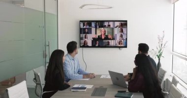 Bir grup iş adamı konferans odasında olgun şirket patronunun ya da proje yöneticisinin konuşmalarını dinlerken detaylar, bilgiler ve noktalar paylaşırlar. Video çağrısı, iş iletişimi
