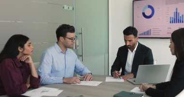 Mutlu iş adamları grup toplantısı veya konferans masasında toplanan pazarlıklar sırasında sözleşme imzaladıktan sonra el sıkışıyor. Ortaklık kurun, karlı bir anlaşmayla birbirinizi tebrik edin.