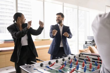 İki çok ırklı meslektaşın langırt oyunu kazanması, dans gibi jestler yapması, zaferi sevinçle kutlaması, aşırı sevinç duyması, modern ofiste komik takım oluşturma aktivitelerinin keyfini çıkarması. Birlik, ruh