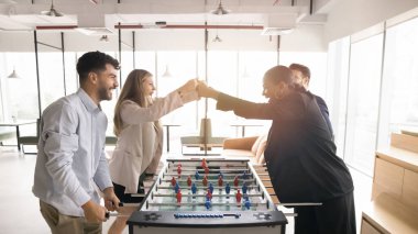 Dört meslektaş birlikte çalışarak langırt oynuyorlar, birbirlerine yumruk tokuşturuyorlar, galibiyeti kutluyorlar, arkadaşça yarışmaların tadını çıkarıyorlar. Takım çalışması, güven, paylaşılan başarı hissi.