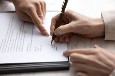 İş ortaklarının elleri kontrat imzalıyor, kağıda işaret ediyor, imza yapıştırıyor. Müşteri, müşteri sigorta acentasıyla anlaşma yapıyor, alıcı satıcıyla anlaşma yapıyor. Yakın çekim.