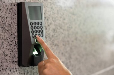 Alarm tuşlarına basan kadın. Elektronik paneldeki tuşlara basan kadın. Ofise ya da eve girebilen kadın. Nesneye yaklaş, kadın elinin kırpılmış görüntüsü.