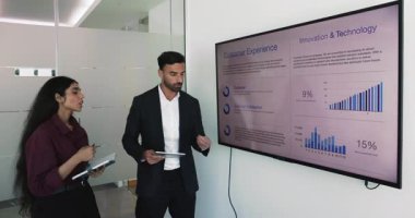 Toplantı odasında gösterilen iki çokuluslu takım arkadaşı değerlendirme slaytı, metin temelli bilgi, veri güdümlü içgörü, görsel bilgi grafikleri, bar çizelgeleri ve dairesel diyagramları tartışıyor