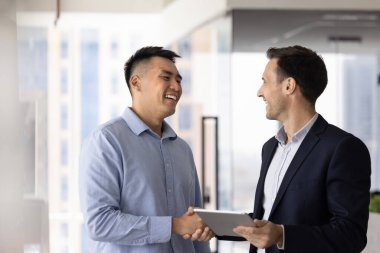 Neşeli Asyalı profesyonel adam hukuk uzmanıyla el sıkışıyor, mali danışman, yardım, danışma, tavsiye, iş arkadaşına el sıkışma, gülümseme, kapanış anlaşması, konuşma, gülme.