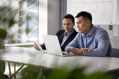 İş yerinde takım çalışması için dijital cihazlar kullanan iki çok ırklı işadamı, çevrimiçi proje, İnternet pazarlama istatistikleri, e-ticaret platformunda satışlar. Gizli çekim.