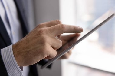 İş dünyasının liderindeki dijital bloknotun yan görüntüsü. İş yönetimi için tablet bilgisayar kullanan profesyonel bir erkek, çevrimiçi iletişim, dokunmatik ekran. Kırpılmış atış