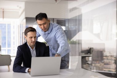 Çevrimiçi başvuru işini tartışan çeşitli iş arkadaşları, internet projesinde çalışmak, dizüstü bilgisayarda birlikte başlamak, bilgisayarda konuşmak, ekrana işaret etmek, takım çalışması için toplantı