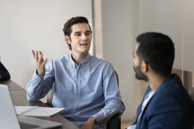İki genç çoklu etnik çeşitlilikte takım arkadaşı ortak projeyle ilgili tartışmalara öncülük ediyor, dizüstü bilgisayarla masaya oturuyor, pazarlama stratejisi geliştirme hakkında konuşuyor, fikir paylaşıyor, çözüm alışverişinde bulunuyor. İş iletişimi