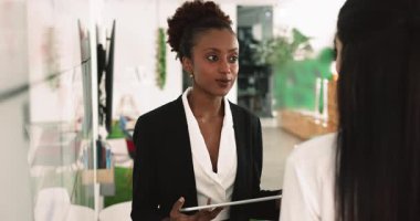 Motive olmuş genç Afrikalı iş kadını beyaz Kanban yönetim kurulunda kadın meslektaşlarıyla konuşuyor, ilham verici iş ortağı, takım çalışması için iş ortağı, proje üzerinde birlikte çalışıyor.