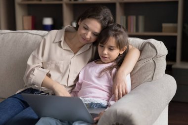 Dijital dünyayı keşfetmek. Sevgi dolu genç annenin kucağında rahat bir kanepede rahatla. Not defteri tut. Eğitim videosu izle.
