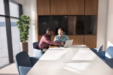 Dizüstü bilgisayar kullanan çok ırklı erkek işçiler çağdaş toplantı odasında buluştu. Yönetici danışma istemcisi, sözleşme detaylarını açıklayın, çevrimiçi sunum gösterme, şirket hizmetlerini paylaşma veya iş stratejisi