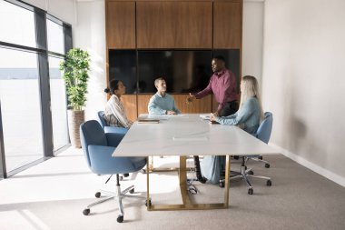 Nişanlı genç takım, Afrikalı patron, koç ya da antrenör liderliğindeki brifinge ya da eğitime katılacak. Personel üyelerinin önünde duracak, konuşma yapacak, yeni proje planı, strateji ya da puan sunacak. İş toplantısı