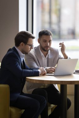 İki genç 35 'lik ofis arkadaşı işbirlikçi görevi gözden geçirip, takım çalışması ve ortaklıkla ilgili iş ortaklığı ortak proje kullanımı dizüstü bilgisayarını tartıştılar. Yönetici müşteriye düşey görünüm için ticari teklifte bulunuyor