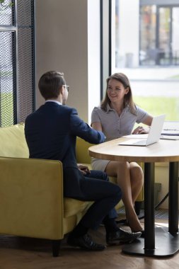 İki genç iş ortağı el sıkışıyor ve anlaşmaya gülümsüyor. Modern çalışma ortamında masada oturan işbirliğine duyduğu saygıyı dile getiriyor. İş görüşmesi izni başvuru sahibi işe alınsın