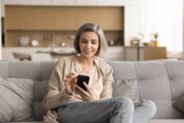 Orta yaşlı çalışan kadın fikirleri paylaşıyor, şirket toplantısı hakkında konuşuyor brifing masasında dizüstü bilgisayar kullanıyor, iş arkadaşlarıyla konuşuyor. Üst düzey işletme öğretmenleri çalışma grubu