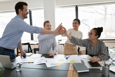 Coşkulu çok ırklı iş adamları iş yerinde ortak zaferi kutlarken beşlik çaktı. Mutlu çok ırklı iş arkadaşları takım oluşturma faaliyetlerinde bulundu. Takım çalışması konsepti.