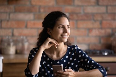 Gülümseyen hayalperest kadın, telefonundan uzaklaşıyor, bir kenara bakıyor, güzel bir gelecek hayal ediyor, fırsatları hayal ediyor, genç bir bayanın sevgilisiyle internette sohbet etmesini ya da evde aramasını bekliyor.
