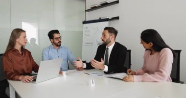30 'lu yaşlarda takım elbiseli bir İspanyol işadamı resmi bir toplantı yapar, konuşur, önerilerde bulunur, konferans odasında hissedarlarla görüşmeler sırasında veya görüşmeler sırasında bilgi veya istişare sunar