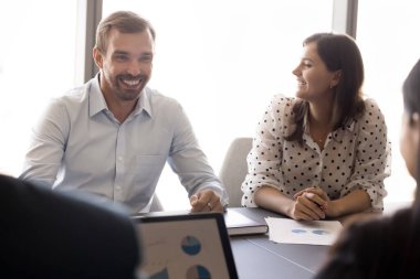 Mutlu takım arkadaşları gülüyor, neşeli ve olumlu atmosferde sohbet ediyor, yaratıcı çözümleri ve sezgileri paylaşıyor, konferans odasında üretken, işbirlikçi ve başarılı takım çalışmalarının tadını çıkarıyor.