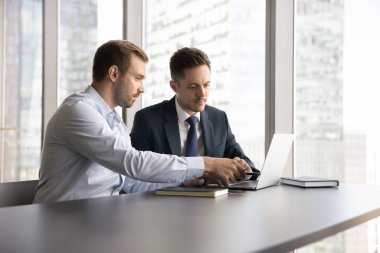 Ortak proje ya da görevde birlikte çalışan meslektaşlar gökdelen ofisinde şehir görüşü olan, dizüstü bilgisayara bakan, fikirleri, çözümleri ve stratejileri paylaşan, işbirliği planlayan, takım çalışmasına katılan iş arkadaşları. Akıl hocalığı