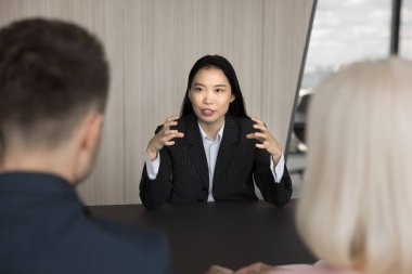 Ciddi genç Asyalı kadın adaylık adayı iki acemi askerin önünde masa başı iş görüşmesini geçerek soruları cevaplıyor. Nitelik, eğitim, insan kaynakları, işgücü