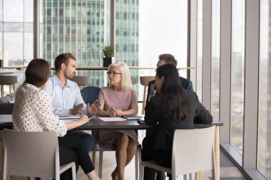 Milenyum erkek takım lideri, toplantı sırasında iş ortaklarıyla bir konuşma yapacak, konferans masasında birlikte oturacak konuşma yapacak, karar verecek, çözümler üretecek, toplantı odasındaki görüşmeler sırasında fikirler sunacak.