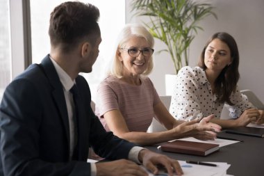Yaşlı ve bin yıllık iş ortakları, gülümseyen çekici iş kadınlarının liderliğindeki toplantı odasında görüşmeler yaptılar, konuşma yaptılar, bilgi verdiler, sözleşme detaylarını anlattılar ve proje gelirlerini anlattılar.