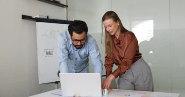 Arapça ve Kafkas takım arkadaşları dizüstü bilgisayar kullanarak ortak proje üzerinde çalışıyor, yeni pazarlama fikirleri geliştiriyor, strateji geliştiriyor, müşterilerle toplantı için sunum hazırlıyor, grafiklerde gösterilen analizler