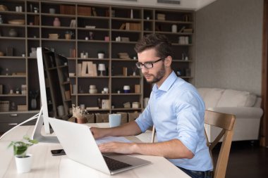 İşinde serbest çalışan bir uzman. Genç erkek veri analisti mali danışman avukat, modern ofis iyi donanımlı evrak işleriyle ilgileniyor. Not defteri ve masaüstü bilgisayarını kullanarak müşteri ile bilgi bağlantısını kontrol ediyor.