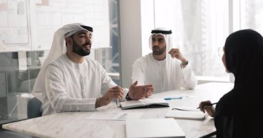 Üç Arap iş adamı modern yönetim kurulunda sohbet ediyorlar. İş adamları geleneksel kanduras giyer ve abaya iş ile ilgili konuşur, karar verme ve yeni proje tartışması için toplanır