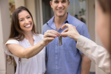 Emlakçı kadın, gülümseyen Avrupalı evli çiftin ev anahtarlarını veriyor. Satın alıyor, kiralıyor ya da kiralıyor. Ev sahipliği, gayrimenkul işlemleri, ve finansal yatırım, yakın çekim