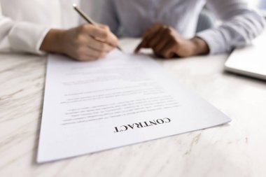 Ofis masasındaki sözleşmeyi imzalayan iş kadınlarıyla kapat. İş danışmanı, danışman, emlakçı imza için yerini işaret ediyor. Kesilmiş vuruşu kapat