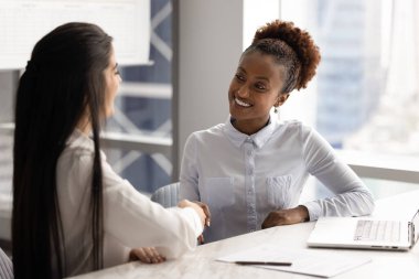Kendine güvenen genç Afrikalı iş kadını iş arkadaşı, partner, danışma toplantısından sonra müşteriyle tokalaşıyor, gülümsüyor. Kadın hukuki danışman müşteriyle tokalaşıyor.